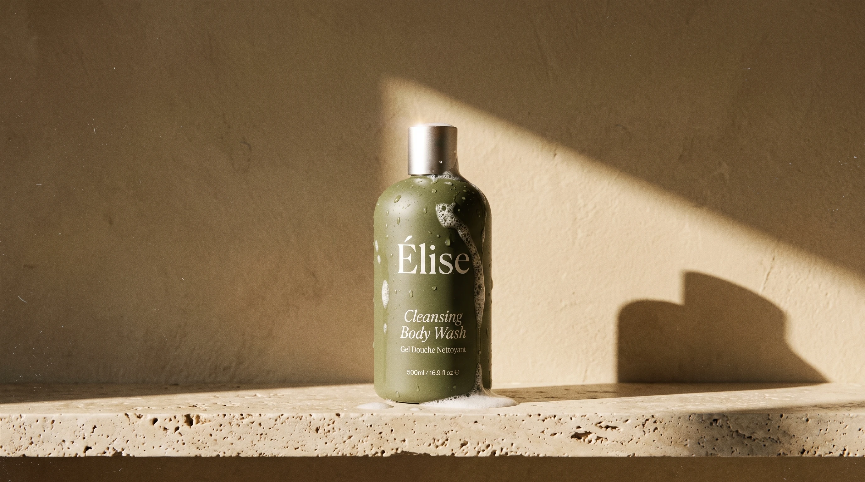 One olive Elise cleansing body-wash bottle grounded on a sunlit stone shelf