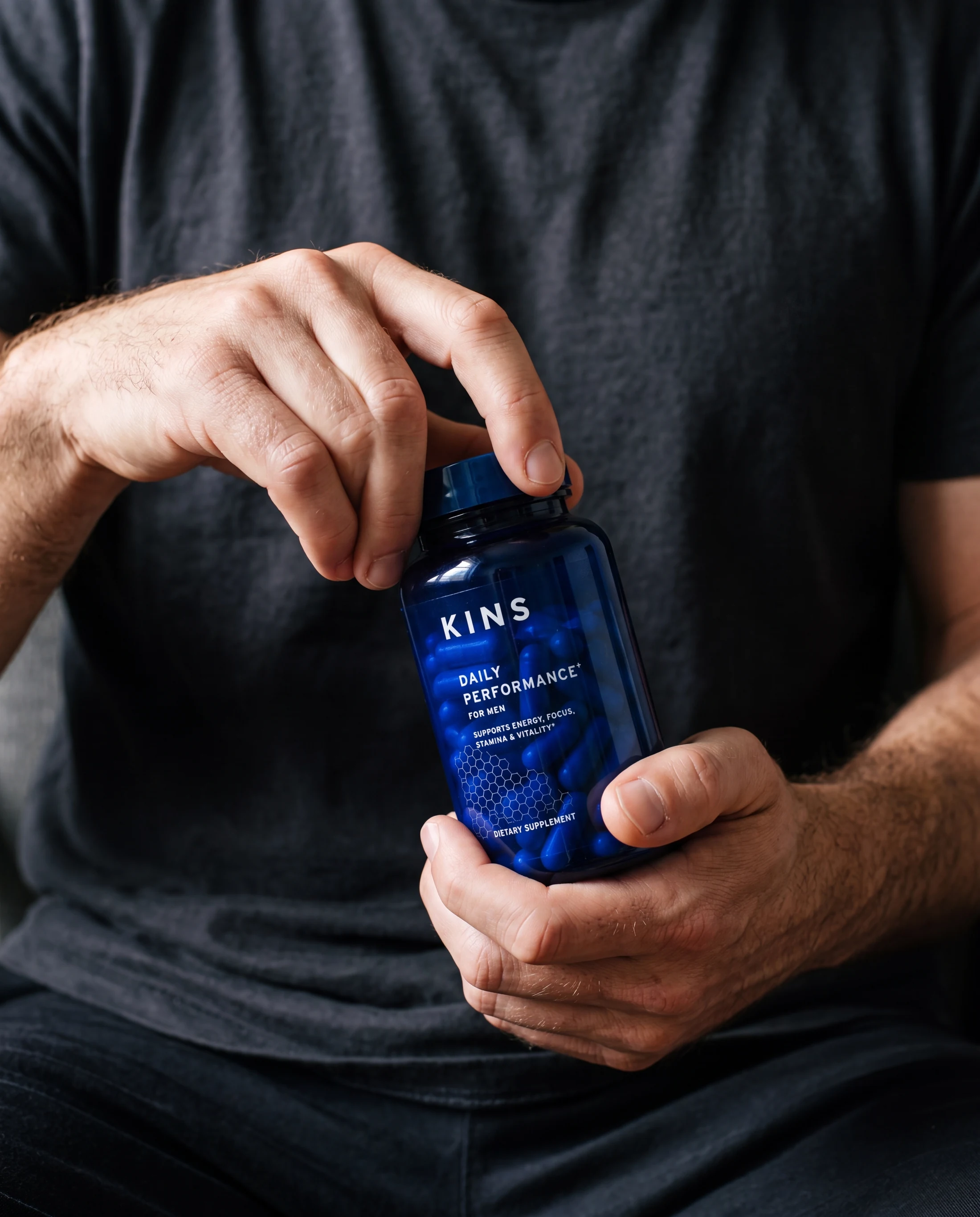 Natural hands opening a palm-sized KINS supplement jar