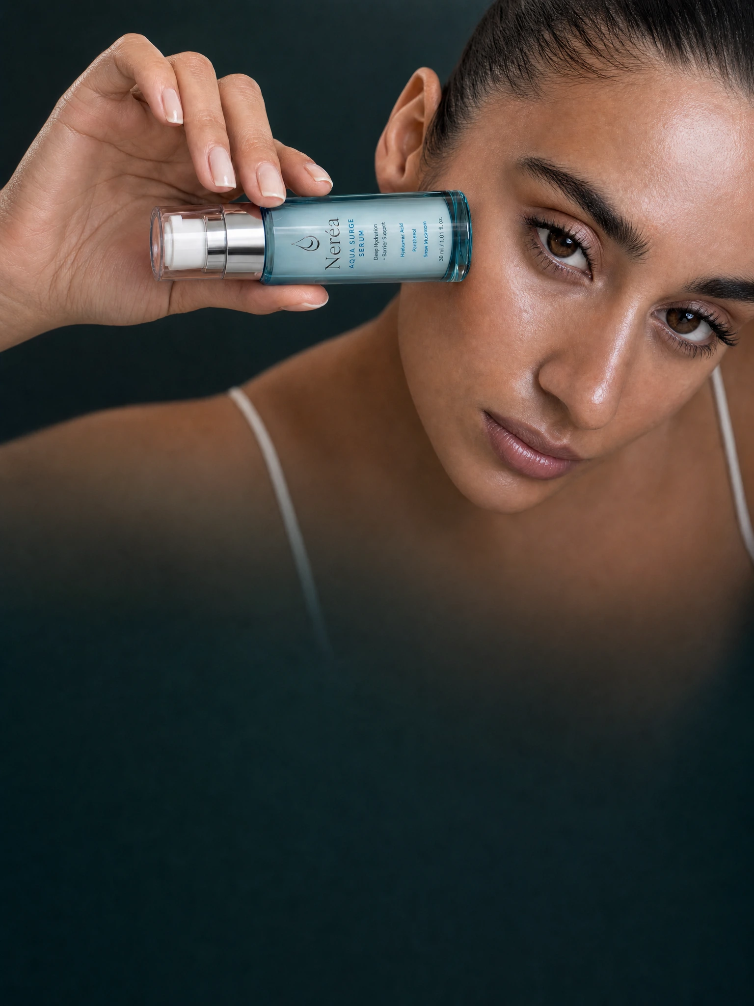 Woman holding Néréa Aqua Surge Serum beside her eye