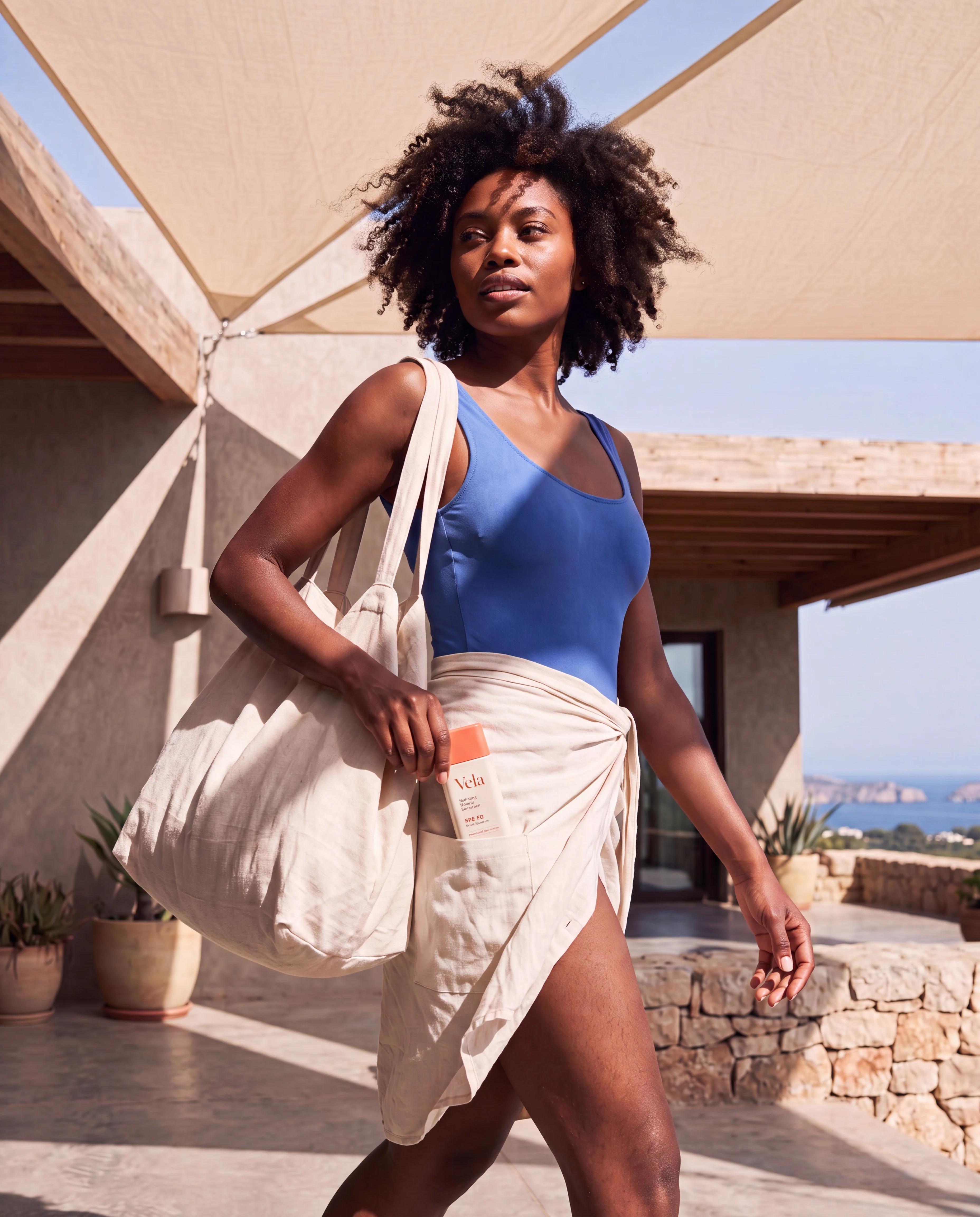 A woman carrying Vela sunscreen naturally beneath sunlit sailcloth